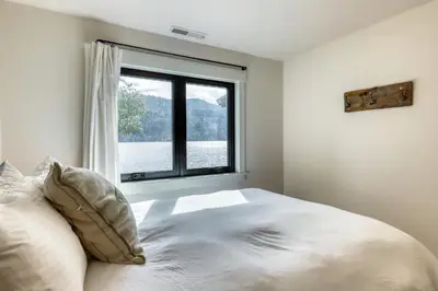 a bedroom with a bed and a large window at Lake Front Family Home at Donner in Truckee