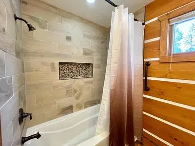 a bathroom with a tub and a shower with a shower curtain at Scenic Wonders & Apt. in Yosemite West