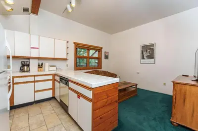 a kitchen with white cabinets and a green floor at Scenic Wonders & Apt. in Yosemite West