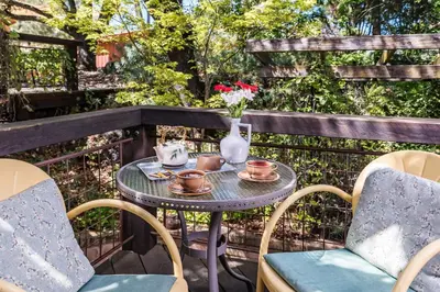 a table with tea pots and flowers on a balcony at Eden Vale Inn in Placerville
