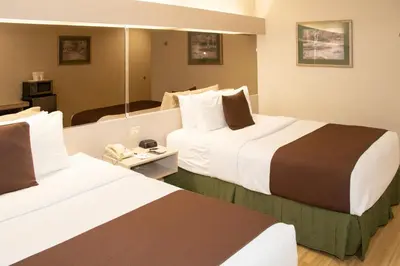 a hotel room with two beds and a mirror at Microtel Inn & Suites Lodi in Lodi