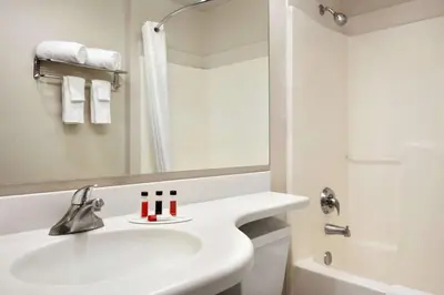 a white bathroom with a sink and a shower at Microtel Inn & Suites Lodi in Lodi