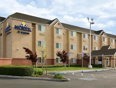 a large hotel with a sign on the front of it at Microtel Inn & Suites Lodi in Lodi