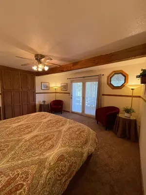 a bedroom with a bed and chairs and a window at Berkshire Inn in Groveland