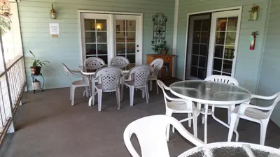 a patio with tables and chairs on a porch at Berkshire Inn in Groveland