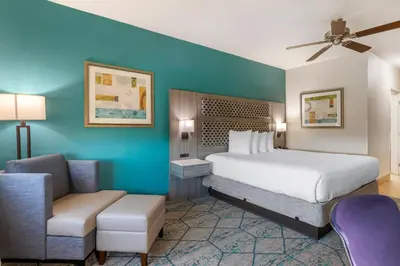 a bedroom with a bed and a couch and a chair at Best Western Plus Wasco Inn & Suites in Wasco
