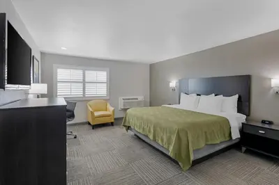 a hotel room with a bed and a yellow chair at Quality Inn Kettleman City near Hwy 41 in Kettleman City