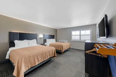 a hotel room with two beds and a flat screen tv at Quality Inn Kettleman City near Hwy 41 in Kettleman City