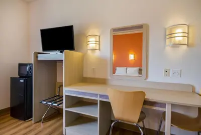 a room with a desk with a computer and a television at Howard Johnson by Wyndham Lemoore in Lemoore