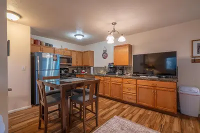 a kitchen with a refrigerator and a table with chairs at Birch Creek #1 - 1BR/1BA - Down Canyon in June Lake