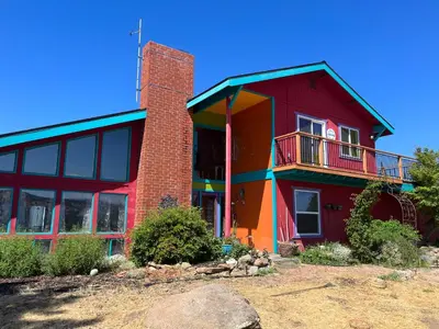 a red building with a balcony on the side of it at McMillan Ranch Yosemite in Coarsegold