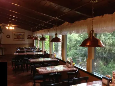a restaurant with tables and chairs and large windows at StrawberryInn River Front Resort in Strawberry