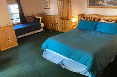 a bedroom with a large bed with blue sheets at Vienna Villa - 3 Bed 3 Bath Vacation home in Shaver Lake in Shaver Lake