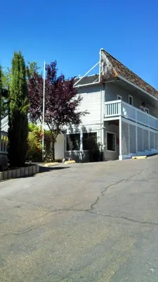 a white building with a parking lot in front of it at Mother Lode Lodge in Mariposa
