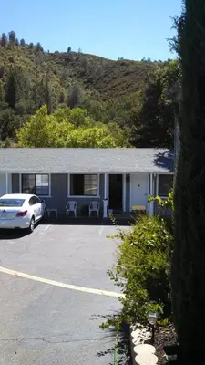 a car parked in a parking lot in front of a building at Mother Lode Lodge in Mariposa