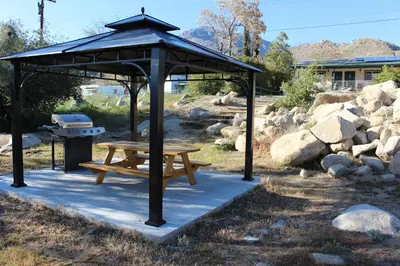 a picnic shelter with a picnic table and a grill at Barewood Inn & Suites in Wofford Heights