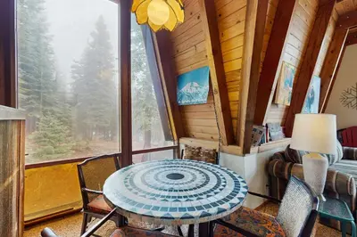 a table and chairs in a room with a window at Retro Family Gathering Home in Tahoe Donner in Truckee