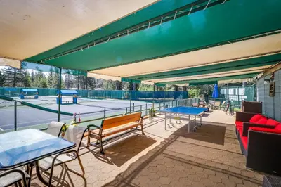 a tennis court with several tables and benches on a tennis court at Tahoe Donner Tree House Retreat in Truckee