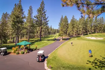 an aerial view of a golf course with people playing golf at Tahoe Donner Tree House Retreat in Truckee