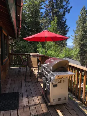 a grill and a table with an umbrella on a deck at Beautiful 3500sf Lake Tahoe Home W/ Open Layout in Zephyr Cove