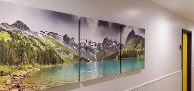 a wall with three paintings of mountains and a lake at The Mammoth Inn in Mammoth Lakes