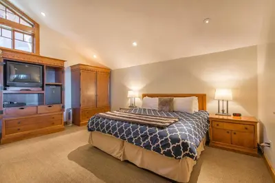 a bedroom with a bed and a flat screen tv at Skislope-Tahoe Villa in Truckee