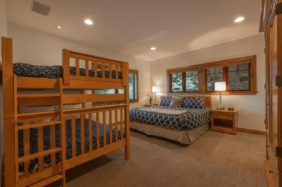 a bedroom with two bunk beds and a staircase at Skislope-Tahoe Villa in Truckee