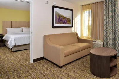 a hotel room with a couch and a bed at Candlewood Suites - Lodi by IHG in Lodi