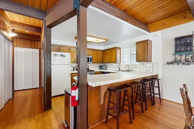 a kitchen with wooden cabinets and a white refrigerator at Relaxed and Comfortable Family Gathering Home in Truckee