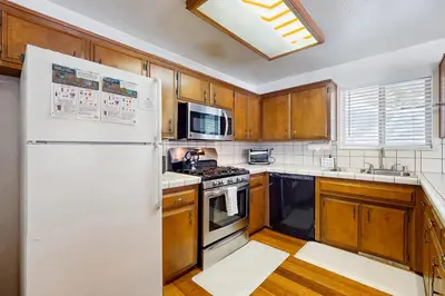 a kitchen with wooden cabinets and a white refrigerator at Relaxed and Comfortable Family Gathering Home in Truckee
