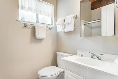 a bathroom with a toilet and a sink and a mirror at Fairway Park Cabin in Incline Village