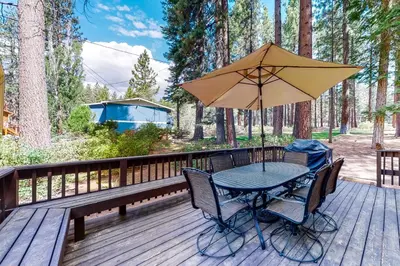 a table and chairs with an umbrella on a deck at Fairway Park Cabin in Incline Village