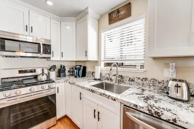 a kitchen with white cabinets and a sink at Fairway Park Cabin in Incline Village