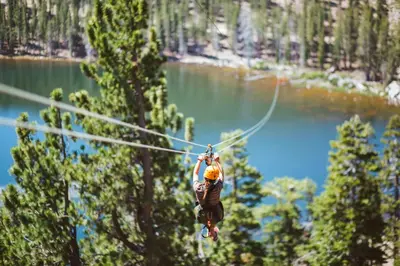 a man on a zip line over a lake at Luxury Two Bedroom Residence Steps From Heavenly Village Condo in South Lake Tahoe