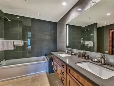 a bathroom with two sinks and a bath tub and a mirror at Luxury Two Bedroom Residence Steps From Heavenly Village Condo in South Lake Tahoe