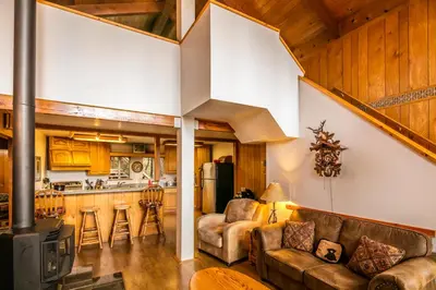 a living room with a couch and a kitchen at Yosemite Cub's Cabin in Yosemite West