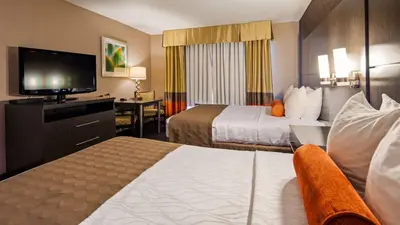 a hotel room with two beds and a flat screen tv at Best Western Plus Rama Inn & Suites in Oakdale