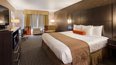 a hotel room with a large bed and a television at Best Western Plus Rama Inn & Suites in Oakdale