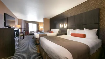 a hotel room with two beds and a flat screen tv at Best Western Plus Rama Inn & Suites in Oakdale