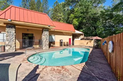 a swimming pool in front of a house at Best Western Plus Yosemite Way Station in Mariposa