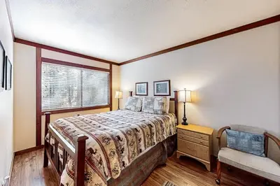 a bedroom with a bed and a window and a chair at Creekside Retreat in Incline Village