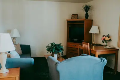 a living room with a blue couch and a tv at Carson City Plaza Hotel in Carson City