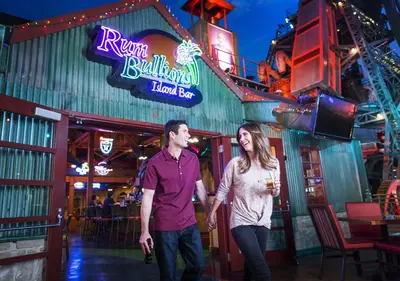 a man and a woman walking in front of a roller coaster at Silver Legacy Reno, A Caesars Destination in Reno