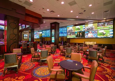 a hotel lobby with tables and chairs and televisions at Silver Legacy Reno, A Caesars Destination in Reno