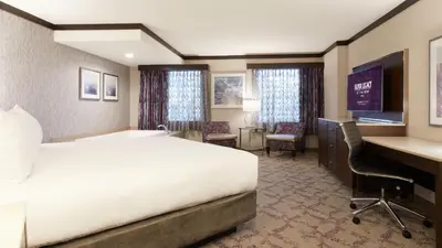 a hotel room with a bed and a desk at Silver Legacy Reno, A Caesars Destination in Reno