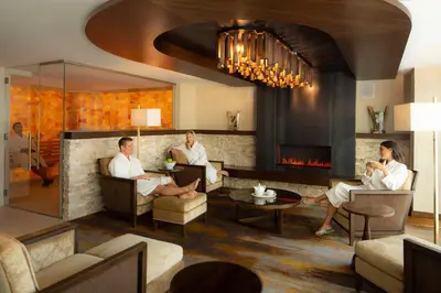 a group of people sitting in a living room with a fireplace at Silver Legacy Reno, A Caesars Destination in Reno