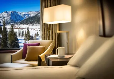 a room with two couches and a window with mountains at Everline Resort and Spa, Lake Tahoe in Olympic Valley
