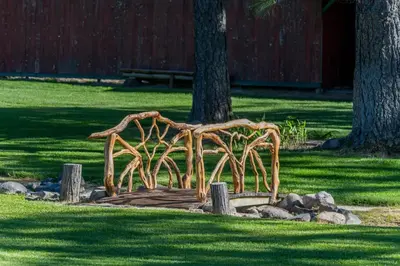 a bench made out of tree branches in a park at The Davies Family Inn in Placerville