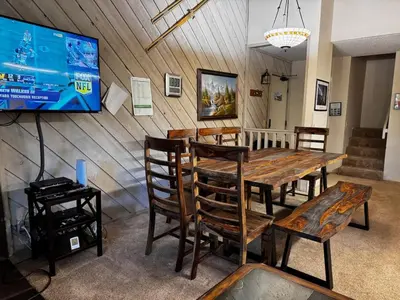 a dining room with a table and chairs and a tv at Mammoth Lakes Crestview Condo #50 in Mammoth Lakes
