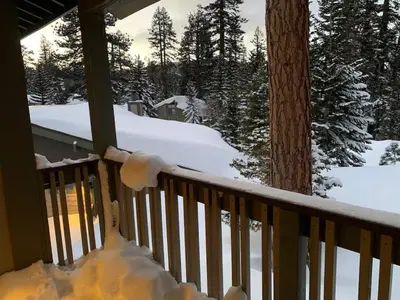 a snow covered railing on a porch with trees at Mammoth Lakes Crestview Condo #50 in Mammoth Lakes